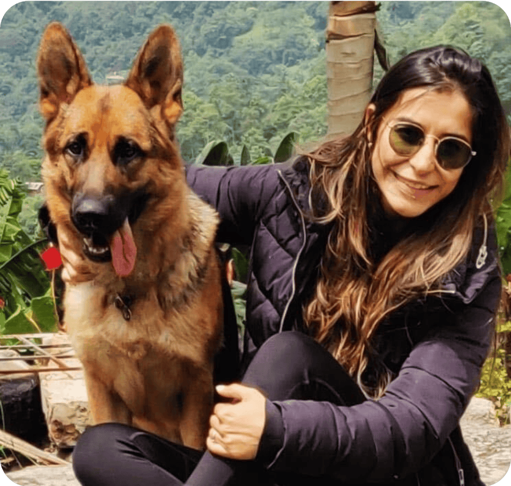 Andrea, fundadora de Pet Mindful, abrazando a su pastor alemán en la montaña